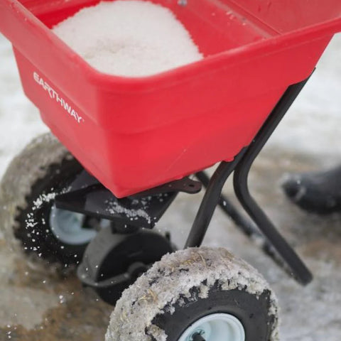 Ice melt being spread through spreader